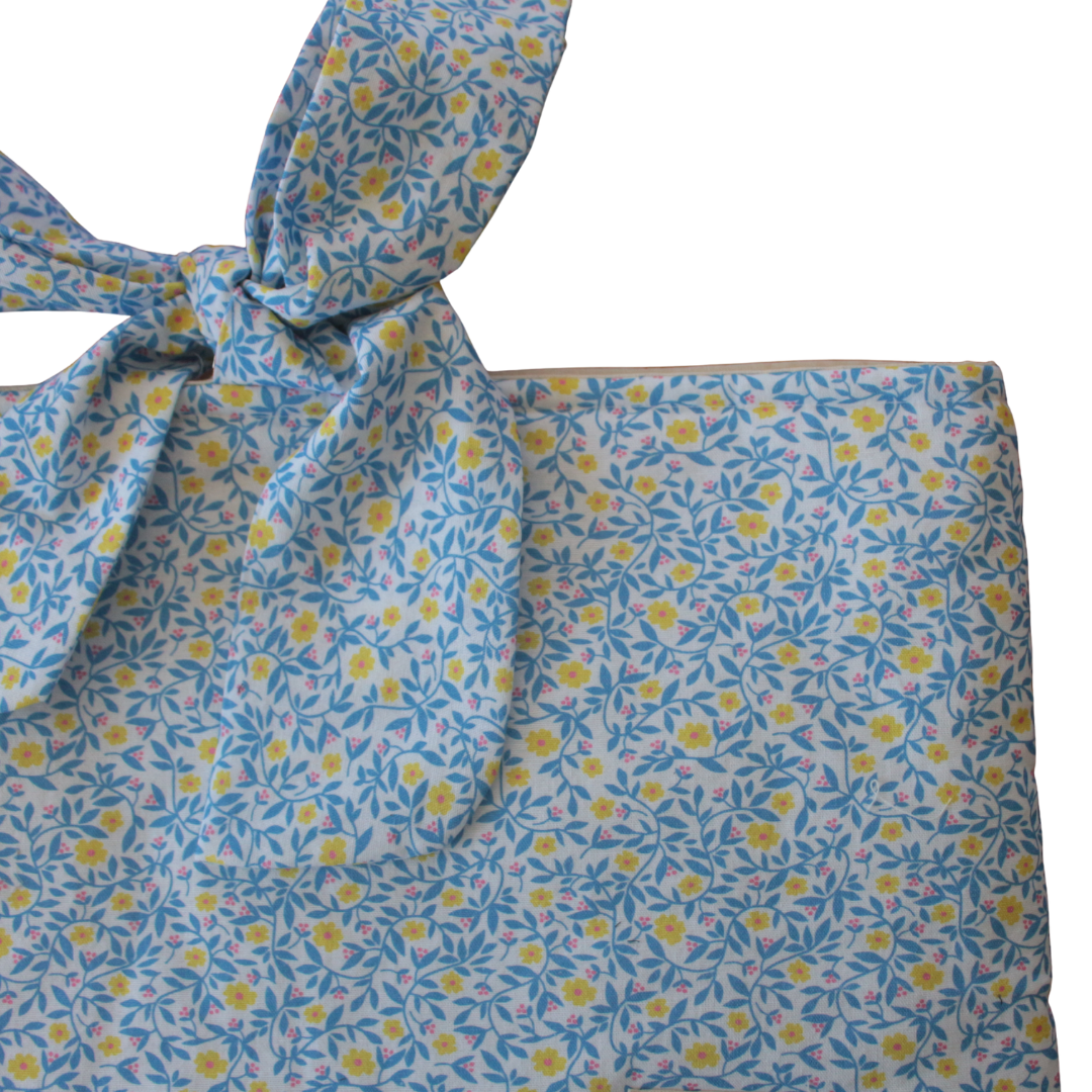 Notepad with colorful illustrations on a bed of straw with plants and a candle.