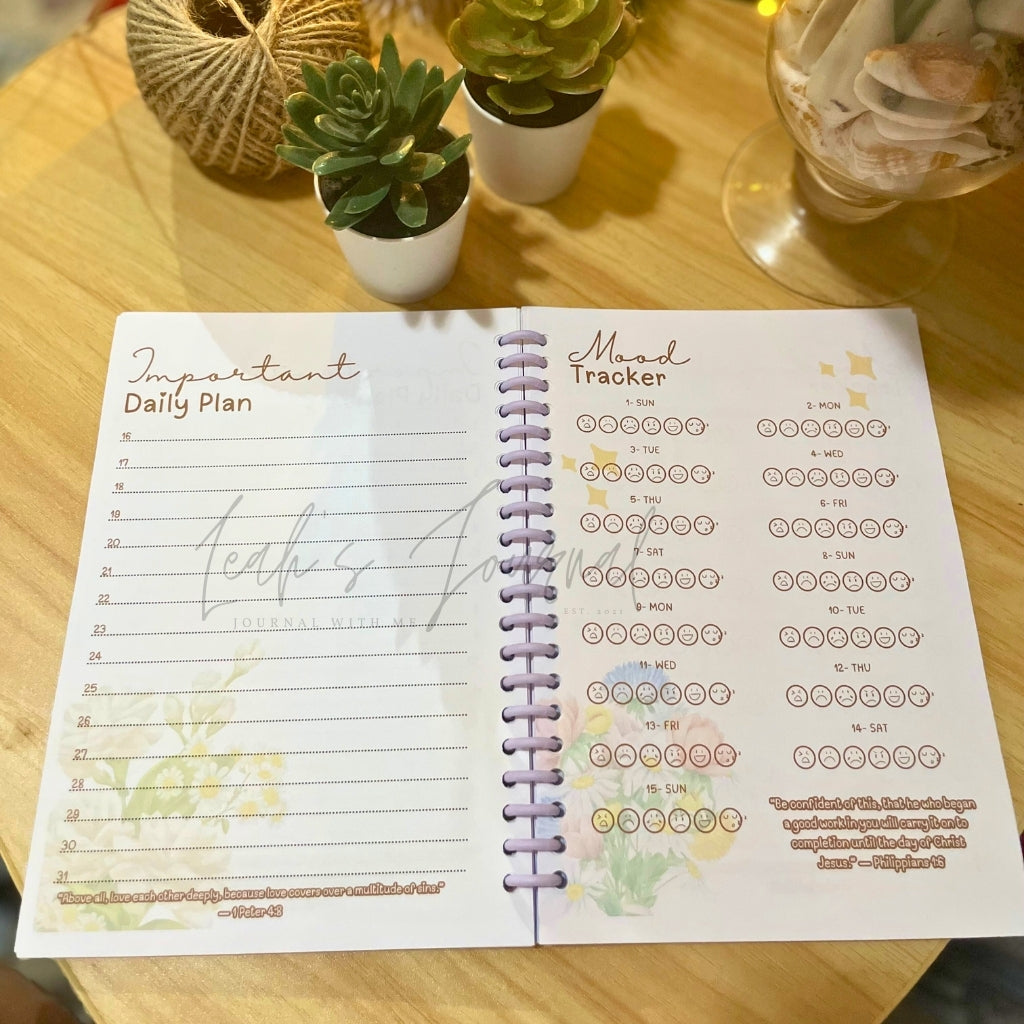 Open planner on a wooden table with plant decor