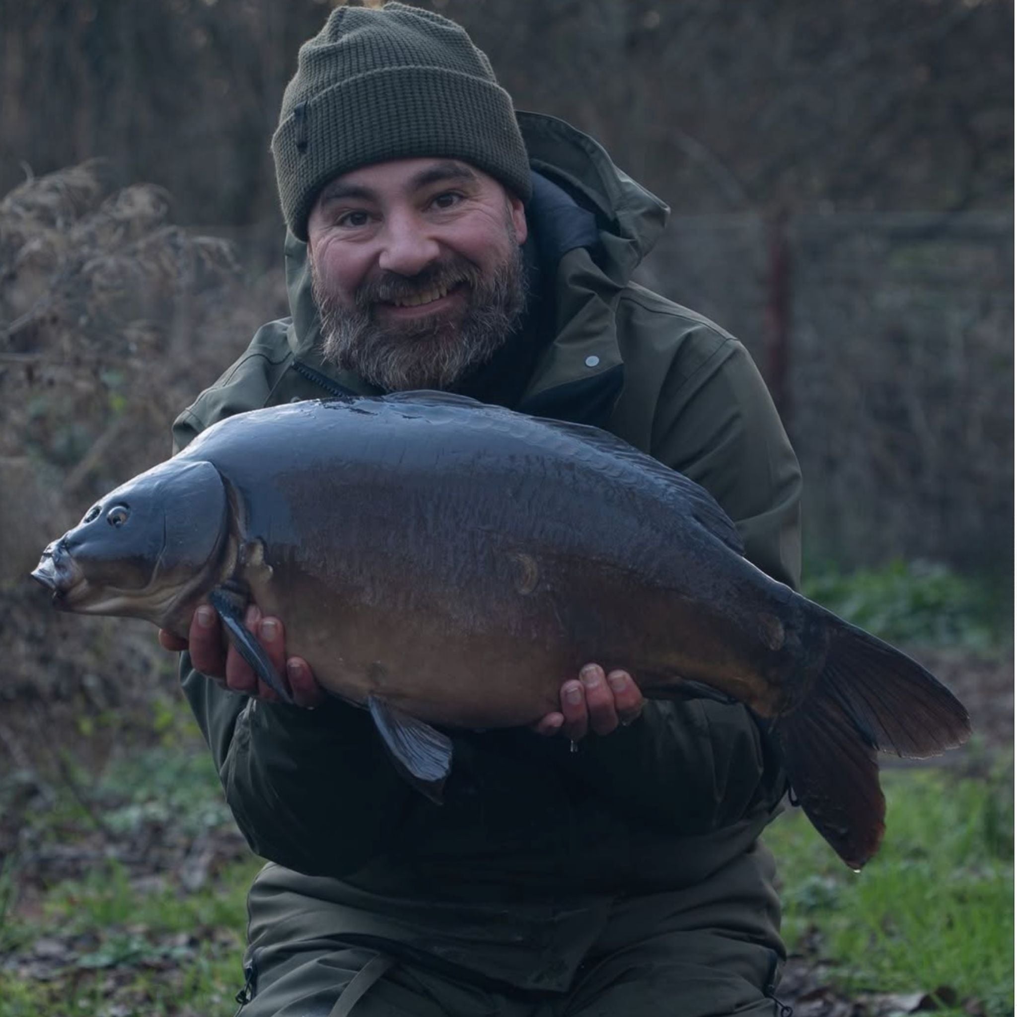 Open weekly planner on a wooden table with plants and a glass in the background